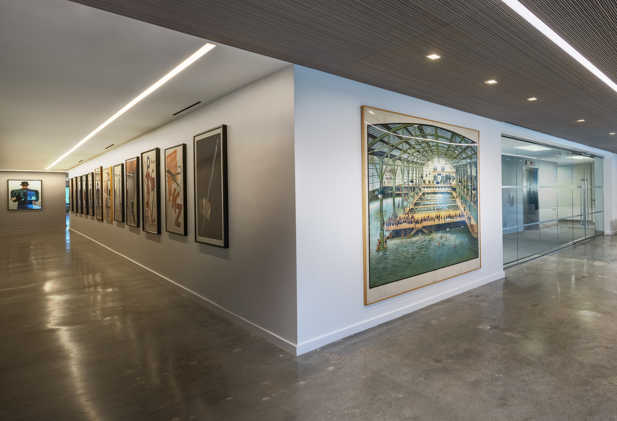 Polished, modern corporate office with receding hallway of posters; white, blue, gray